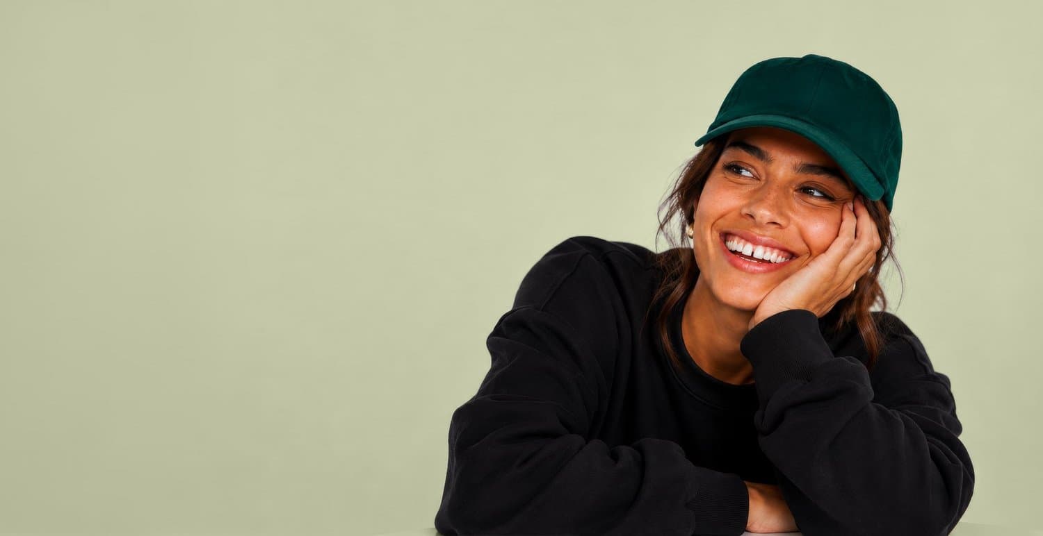Smiling woman wearing a green B-Life Care cap