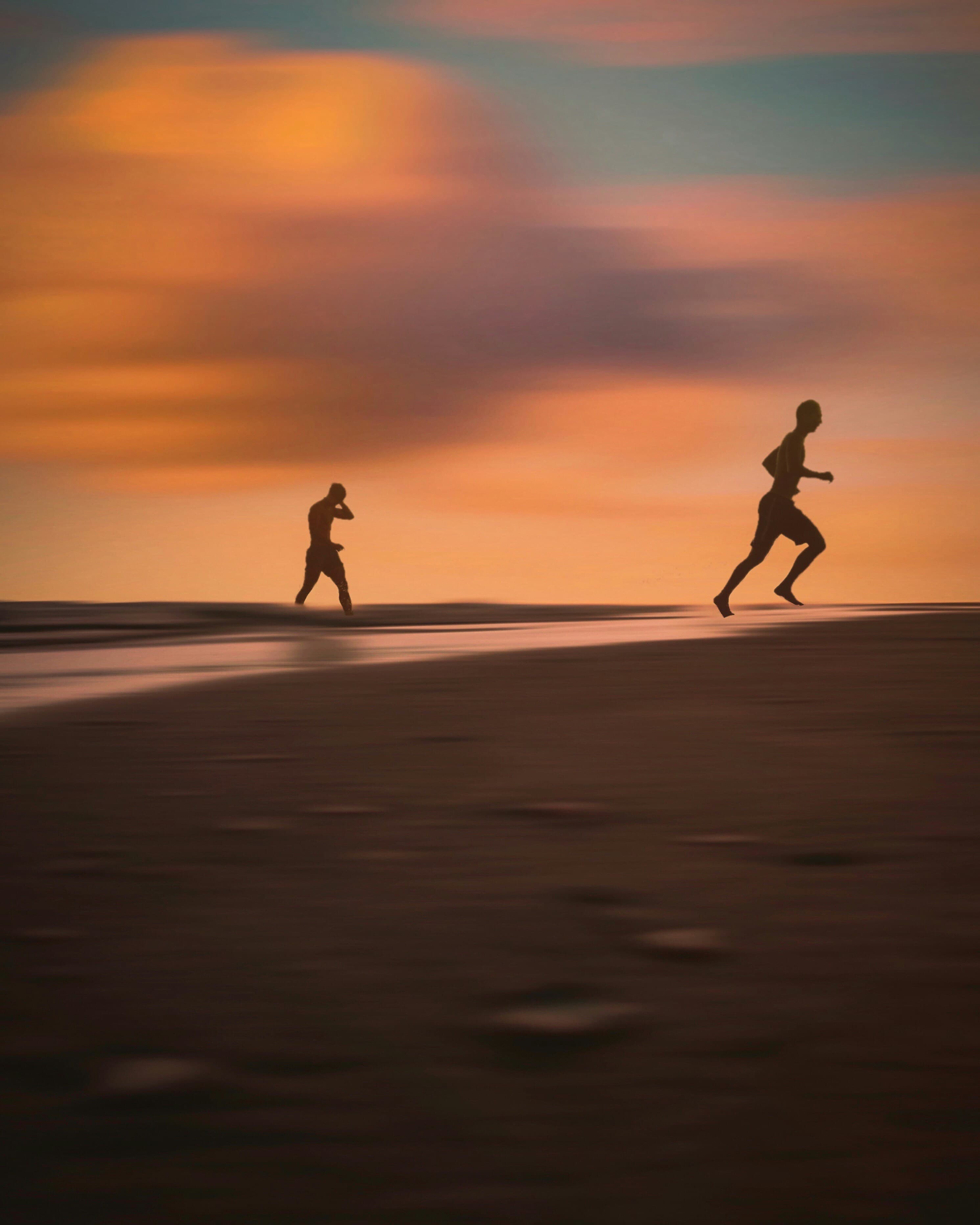 Two runners on the beach at sunset